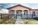 Charming home featuring a covered porch with stone pillars and black metal fencing at 15501 E 112Th Ave # 30A, Commerce City, CO 80022