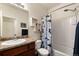 Cozy bathroom with shower/tub combo, granite vanity, and decorative shelving at 1836 Taos St, Brighton, CO 80603