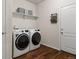 Well-lit laundry room with modern front load washer and dryer on beautiful wood-look floors at 1836 Taos St, Brighton, CO 80603