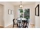 Dining area with a round table, contemporary chandelier, and sliding door access to the backyard at 2986 S Elm St, Denver, CO 80222