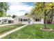 Quaint single-story home featuring a well-kept lawn, walkway, and an attached garage at 2986 S Elm St, Denver, CO 80222