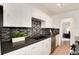 Updated kitchen with dark counters, white cabinets, and modern backsplash at 2986 S Elm St, Denver, CO 80222
