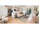 Well-lit living area with modern furniture, wood floors, open layout to kitchen and dining area at 2986 S Elm St, Denver, CO 80222