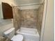 Bathroom featuring a tiled shower over tub, built-in shelving, and a white toilet at 1111 S Garrison St # 202, Lakewood, CO 80232