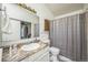 Neutral bathroom features a granite countertop, undermount sink, and shower with a gray patterned curtain at 1111 S Garrison St # 202, Lakewood, CO 80232
