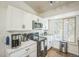 Modern kitchen featuring white cabinetry, stainless steel appliances, and wood-look flooring at 1111 S Garrison St # 202, Lakewood, CO 80232