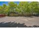 Exterior shot of a parking lot with marked spots and mature trees in the background at 1111 S Garrison St # 202, Lakewood, CO 80232