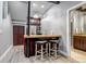 Cozy bar area with dark wood cabinetry, a stylish countertop, and seating for casual entertaining at 6715 Raritan Dr, Denver, CO 80221