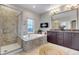 Bright bathroom featuring a glass shower, soaking tub, double vanity, and neutral finishes at 6715 Raritan Dr, Denver, CO 80221