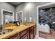 Elegant bathroom with a dual sink vanity with stone counters and a modern standalone soaking tub at 6715 Raritan Dr, Denver, CO 80221