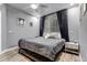 Contemporary bedroom with a large window and a comfortable gray bedspread at 6715 Raritan Dr, Denver, CO 80221