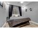 Contemporary bedroom featuring a gray bedspread and natural light from a large window at 6715 Raritan Dr, Denver, CO 80221