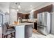 Well-lit kitchen featuring a spacious island with bar seating, stainless steel refrigerator, and modern appliances at 6715 Raritan Dr, Denver, CO 80221