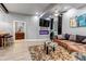 Modern living room featuring a sleek fireplace, comfortable seating, and a view into an adjacent bar area at 6715 Raritan Dr, Denver, CO 80221