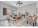 Bright living room featuring hardwood floors, neutral tones, a ceiling fan, and many large windows at 6715 Raritan Dr, Denver, CO 80221