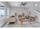 Bright living room featuring hardwood floors, neutral tones, a ceiling fan, and view of stairway at 6715 Raritan Dr, Denver, CO 80221