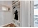 Mudroom with built in storage featuring hooks, open shelving, and bench seating at 6715 Raritan Dr, Denver, CO 80221