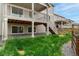 Exterior view of a home with a backyard featuring green grass and stone at 4666 S Malaya Ct, Aurora, CO 80015