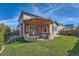 Landscaped backyard features a pergola, hot tub, stone patio, and green lawn at 12510 Fisher St, Englewood, CO 80112