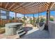 Inviting backyard with hot tub, stone patio, pergola with string lights, and hammock at 12510 Fisher St, Englewood, CO 80112
