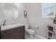 A stylish powder room featuring a modern vanity, round mirror, and a decorative cabinet at 12510 Fisher St, Englewood, CO 80112