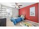A bedroom with red accent wall, ceiling fan, and playful rug at 12510 Fisher St, Englewood, CO 80112