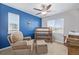 A bedroom featuring blue accent wall, chair and crib, and a ceiling fan at 12510 Fisher St, Englewood, CO 80112