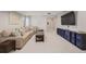 Bright living room features neutral carpet, a sectional couch, and modern shelving at 12510 Fisher St, Englewood, CO 80112