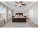 A spacious main bedroom featuring a tray ceiling, a ceiling fan, and a decorative rug at 12510 Fisher St, Englewood, CO 80112