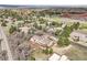 Expansive aerial view showcasing the beautiful neighborhood, lush greenery, and golf course at 6201 Rain Dance Trl, Littleton, CO 80125