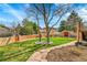 Charming backyard featuring a lush lawn, stone pathways, walled garden, and mature trees at 6201 Rain Dance Trl, Littleton, CO 80125