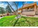The beautiful yard features a lovely green lawn, stone patio, and stucco wall at 6201 Rain Dance Trl, Littleton, CO 80125