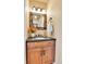 Stylish half bathroom with wood vanity, granite countertop, and decorative mirror at 6201 Rain Dance Trl, Littleton, CO 80125