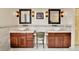 Dual vanity bathroom featuring vessel sinks, decorative tile backsplash, sconces, and wood cabinets at 6201 Rain Dance Trl, Littleton, CO 80125