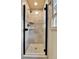 Walk-in shower with tile surround and glass door at 6201 Rain Dance Trl, Littleton, CO 80125
