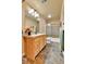 Bathroom with vessel sink, wood vanity, stone tile floor and a framed mirror at 6201 Rain Dance Trl, Littleton, CO 80125