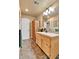 Bright bathroom features custom tiling, wood vanity, and a rustic wood cabinet at 6201 Rain Dance Trl, Littleton, CO 80125