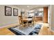 Bright dining room with wood floors, rug, and modern decor with views leading into the kitchen at 6201 Rain Dance Trl, Littleton, CO 80125