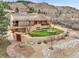 Stunning home with stucco walls, beautiful landscaping, and mature trees nestled in a hillside setting at 6201 Rain Dance Trl, Littleton, CO 80125