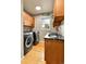 Functional laundry room with washer, dryer, sink and wood cabinets at 6201 Rain Dance Trl, Littleton, CO 80125