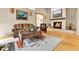 Cozy living room boasts hardwood floors, stone fireplace, and comfortable furnishings at 6201 Rain Dance Trl, Littleton, CO 80125