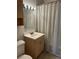 A functional bathroom features a shower with a curtain, a light wood vanity, and a toilet at 2500 S York St # 401, Denver, CO 80210