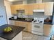 Virtually staged kitchen with light wood cabinets, granite countertops, and white appliances at 2500 S York St # 401, Denver, CO 80210