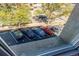 View of assigned parking spots in a lot framed by trees, as seen from a window at 2500 S York St # 401, Denver, CO 80210