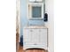 Bathroom vanity with white cabinets, marble countertop, white trim, and blue accent wall at 10422 Nelson Ct, Broomfield, CO 80021