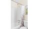 Bright bathroom with white tiled walls, a showerhead and white shower curtain with purple flower pattern at 10422 Nelson Ct, Broomfield, CO 80021
