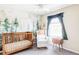 Cozy Bedroom with nature themed mural, comfortable rocker, and bright window with curtains at 10422 Nelson Ct, Broomfield, CO 80021