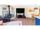 Open living room with wood-burning stove, TV, wood floors, and dining table and chairs at 10422 Nelson Ct, Broomfield, CO 80021
