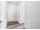 White hallway with hardwood floors and several doors at 9688 Winterset Cir, Littleton, CO 80125