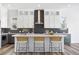 Modern kitchen with white cabinets, grey backsplash, large island, and seating for three at 9688 Winterset Cir, Littleton, CO 80125